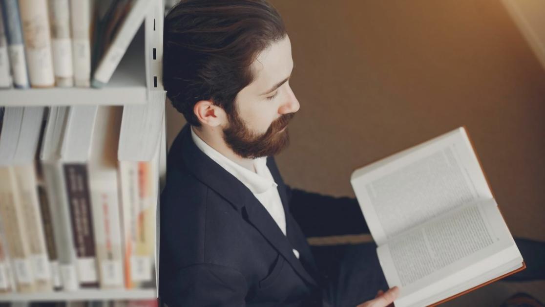 Student working on web design project using modern development tools and creative planning materials